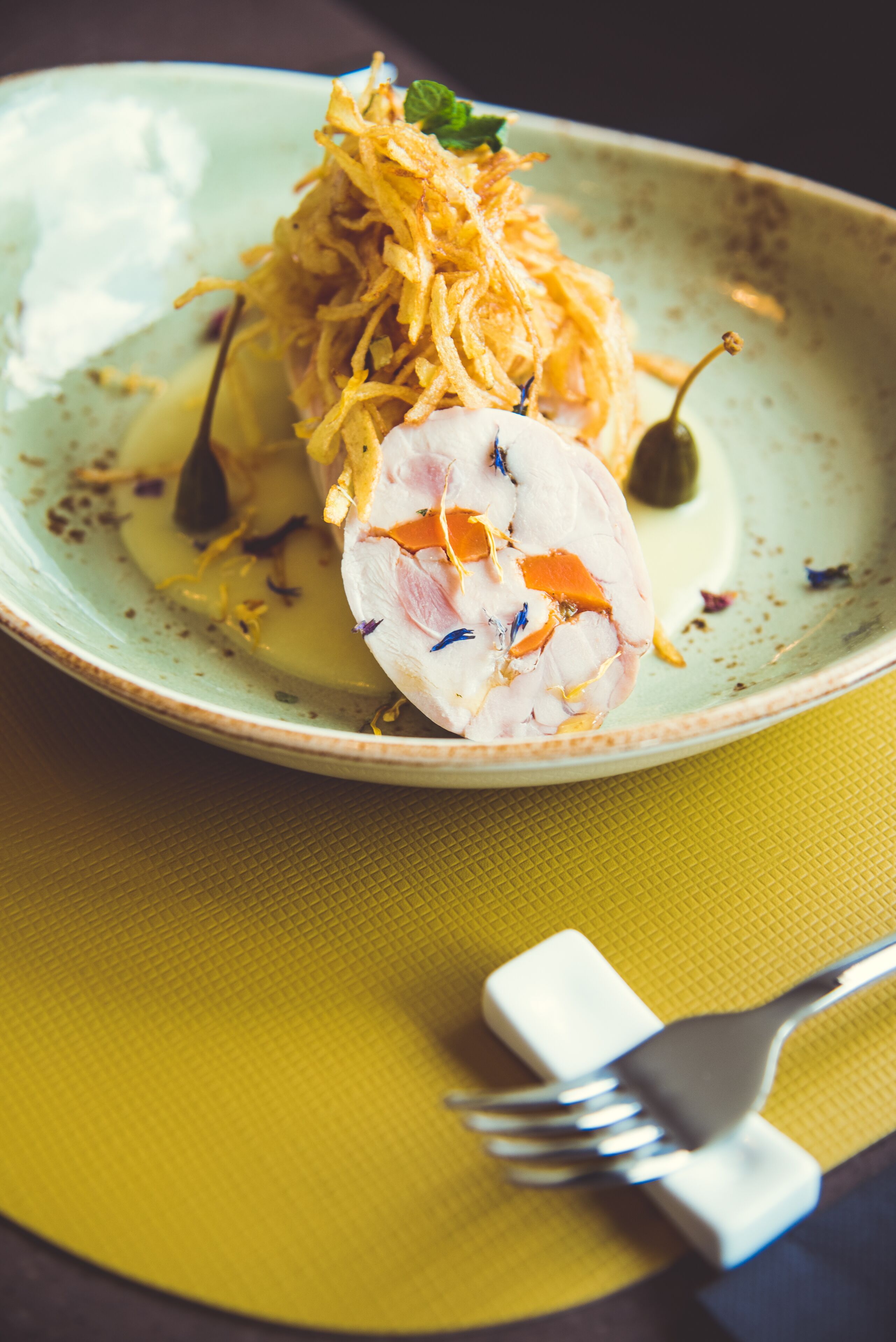A plate with a dish, a fork, and a napkin.