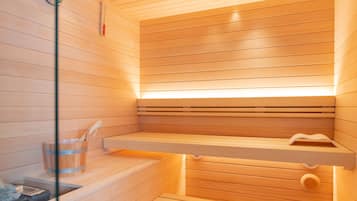 A sauna with wooden slats, a wooden bench, a small wooden bucket, and a glass container.