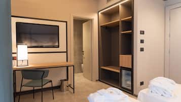 Une chambre d’hôtel équipée d’un bureau, d’une chaise, de deux lits, d’une armoire et d’une salle de bain.