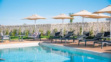 Piscine extérieure, parasols de plage, chaises longues