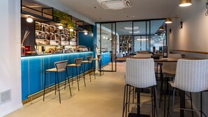 Un espace bar moderne aux accents bleus, doté de tabourets et offrant différents types de sièges.