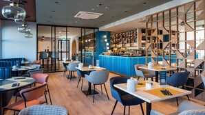 Un intérieur de restaurant moderne avec des tables, un bar et un escalier.