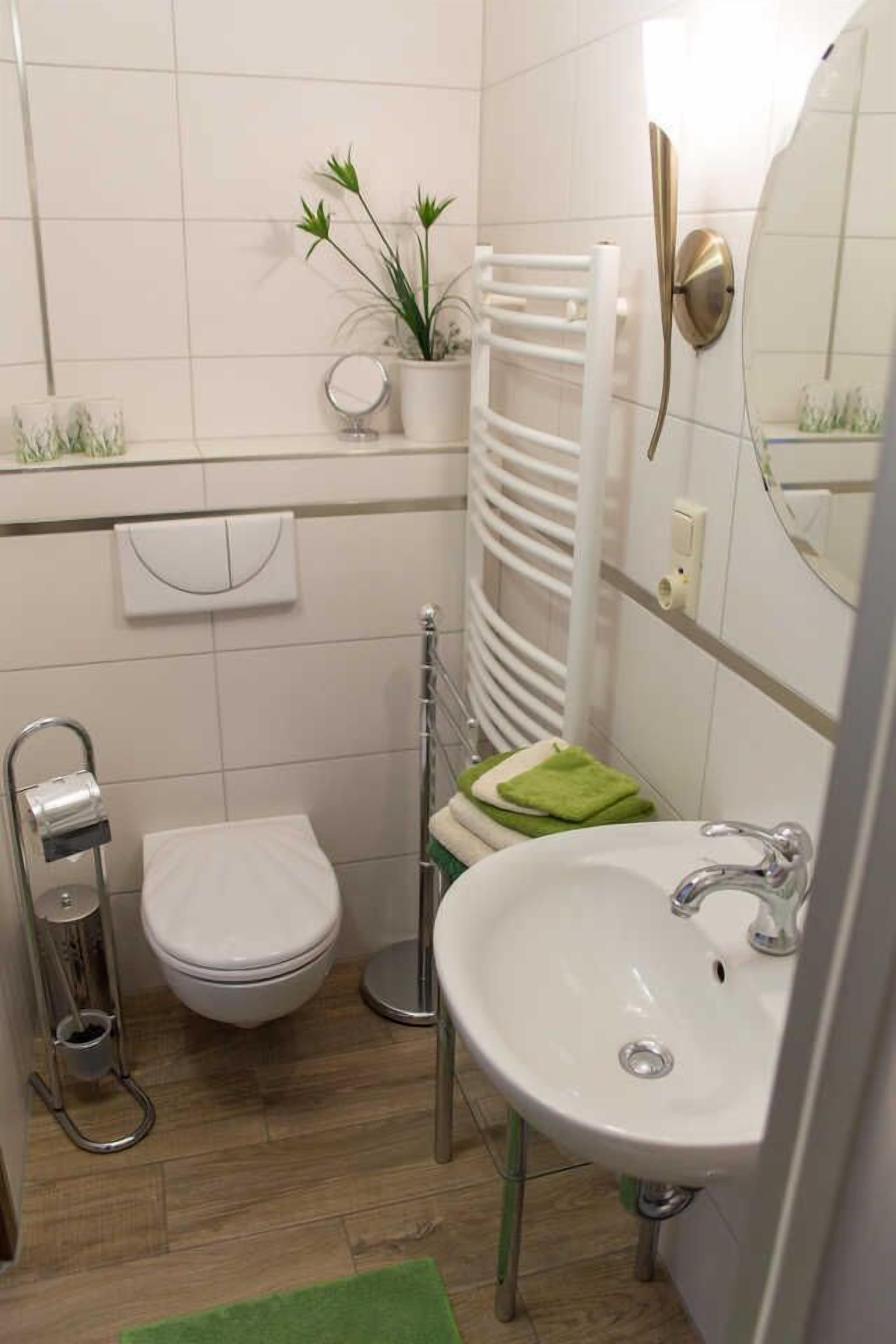 A modern bathroom with a toilet, sink, and towel rack.