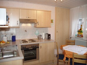 A compact kitchen with a built-in oven, a coffee maker, and a toaster.