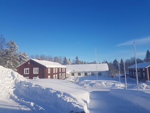A snow-covered residential area with houses and a clear blue sky. - Lövångergården (Lövånger)