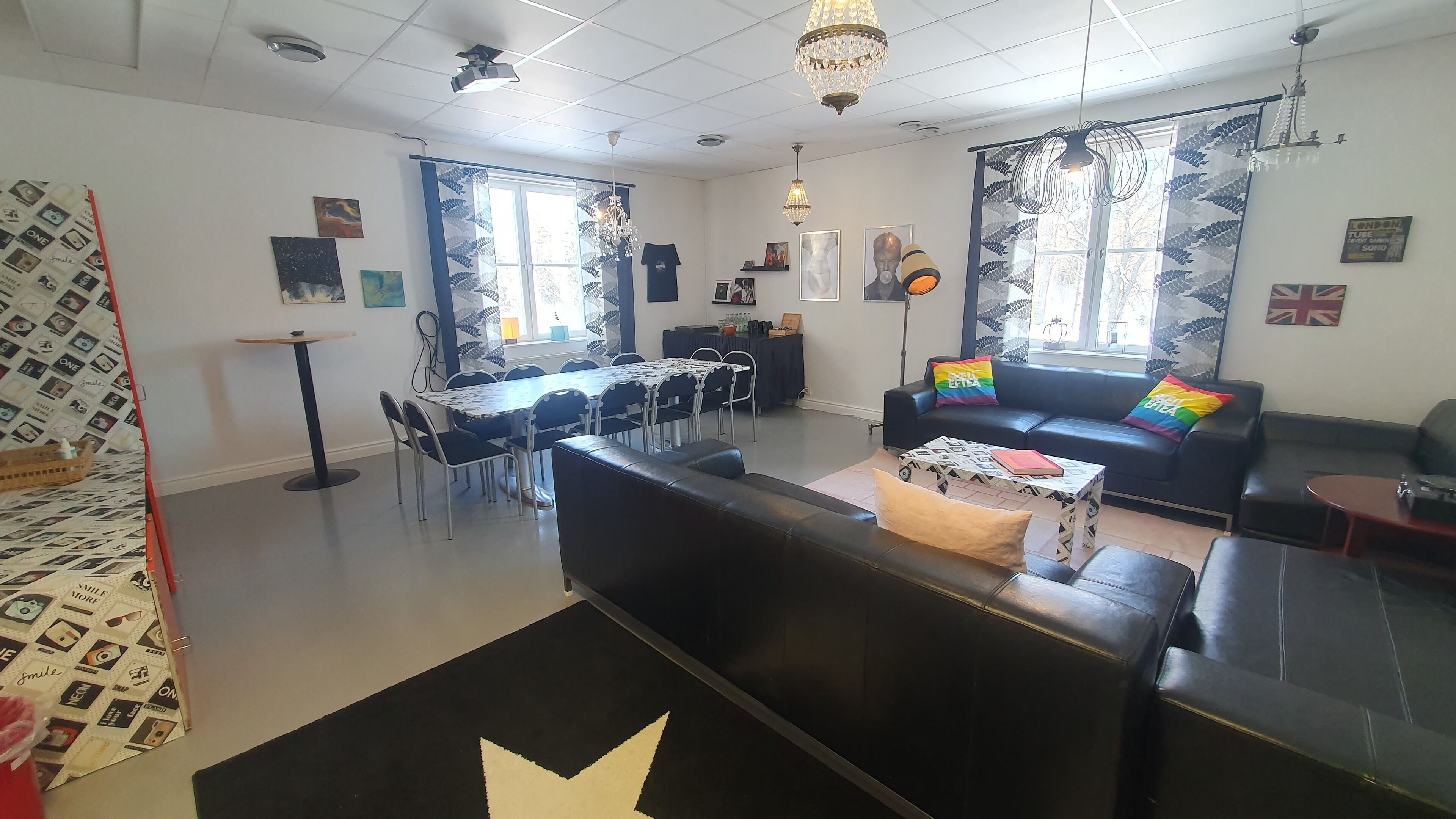 Un salon moderne avec un canapé en cuir noir, une table à manger avec des chaises et une table basse.