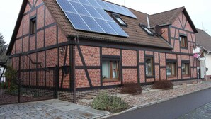 Una casa tradicional de entramado de madera con paneles solares en el tejado.