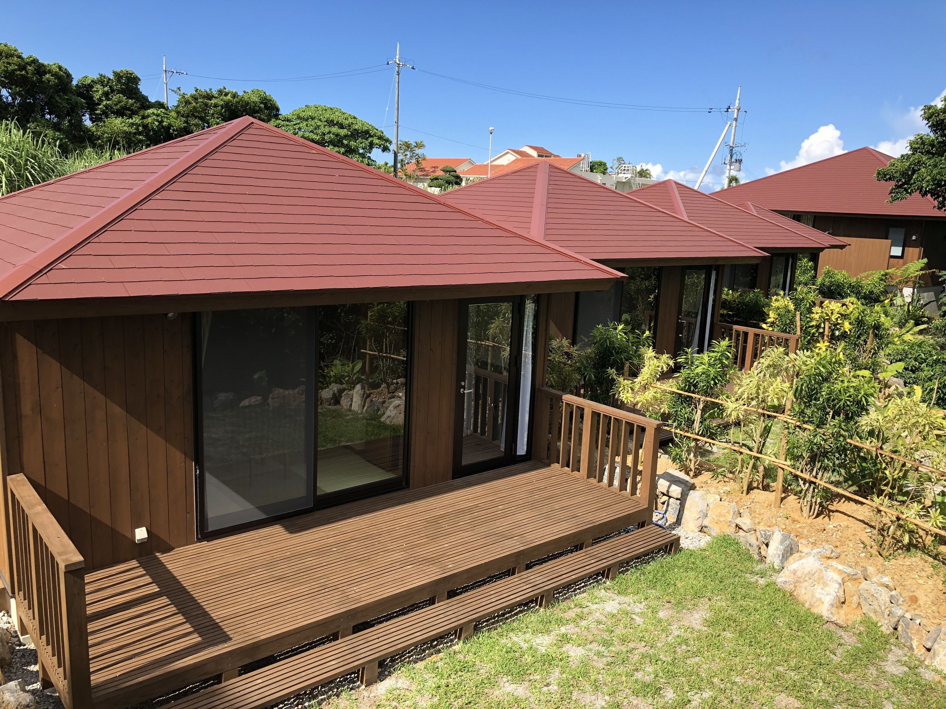 Un pontile in legno con una porta vetrata che dà su una stanza con tetto rosso.