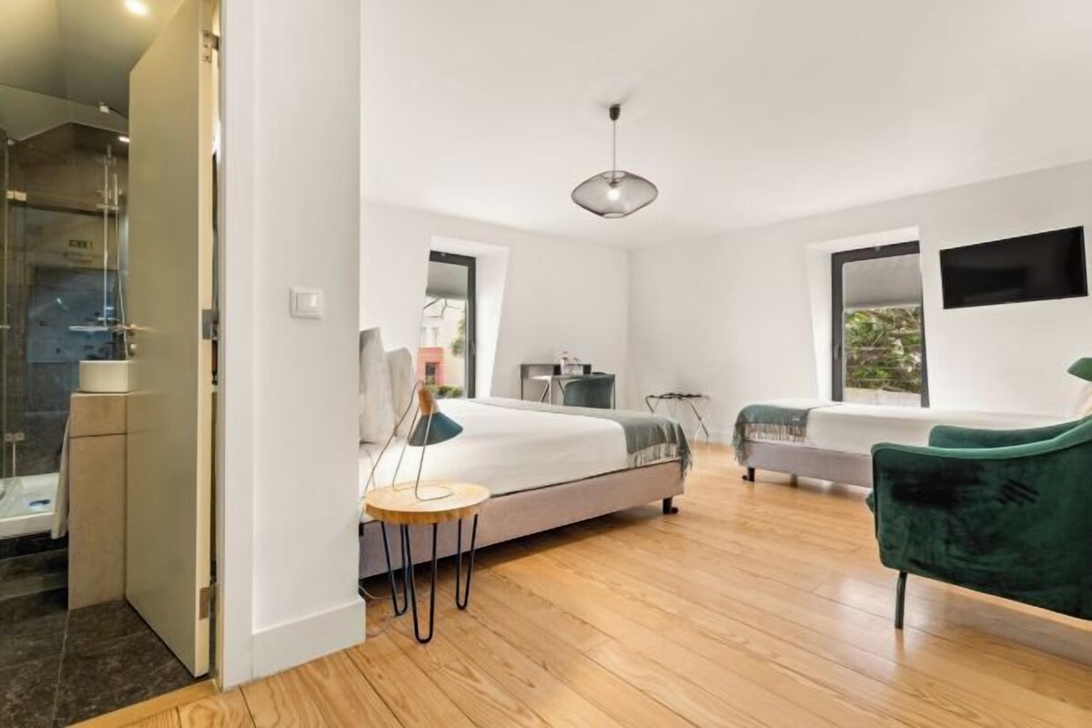 Un dormitorio moderno con una cama, una mesita de noche y una silla verde.