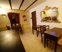 Un comedor con mesas y sillas de madera, una bicicleta roja y un espejo grande y decorado en la pared.