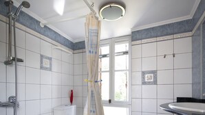 A bathroom with a shower, toilet, and sink.