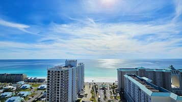A high-rise hotel with a view of the beach and ocean.