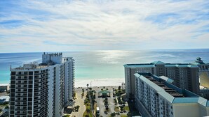 A high-rise hotel with a beach view, featuring multiple balconies, a central courtyard, and a parking area. - AD 1 2104, a spacious 2-bedroom condo in Destin, Fabulous views (Destin)