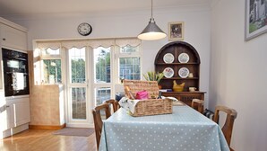 A dining area with a table set for four, surrounded by wooden chairs, a wicker basket, and a blue polka dot tablecloth. - Little Crossways , Goodwood -  an annexe that sleeps 2 guests  in 1 bedroom (Chichester)