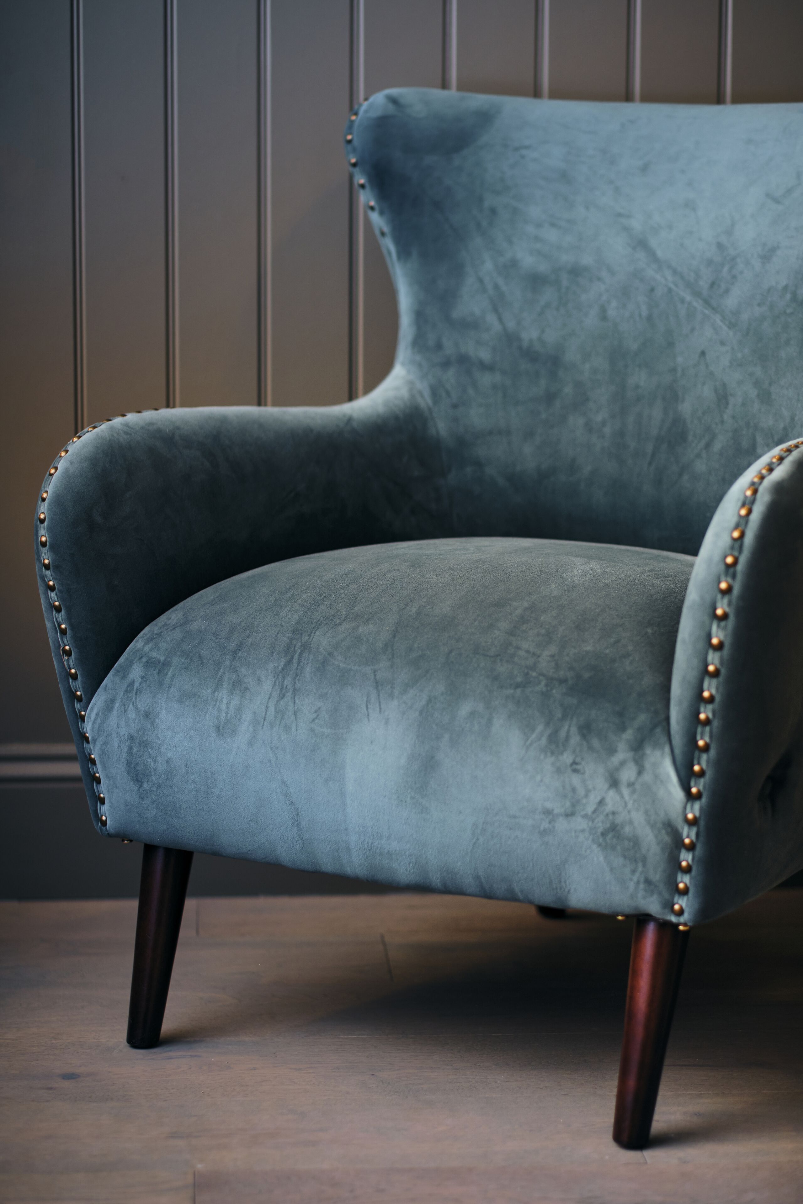Una silla con asiento y respaldo acolchados, adornada con un ribete de cuentas a lo largo de los bordes.