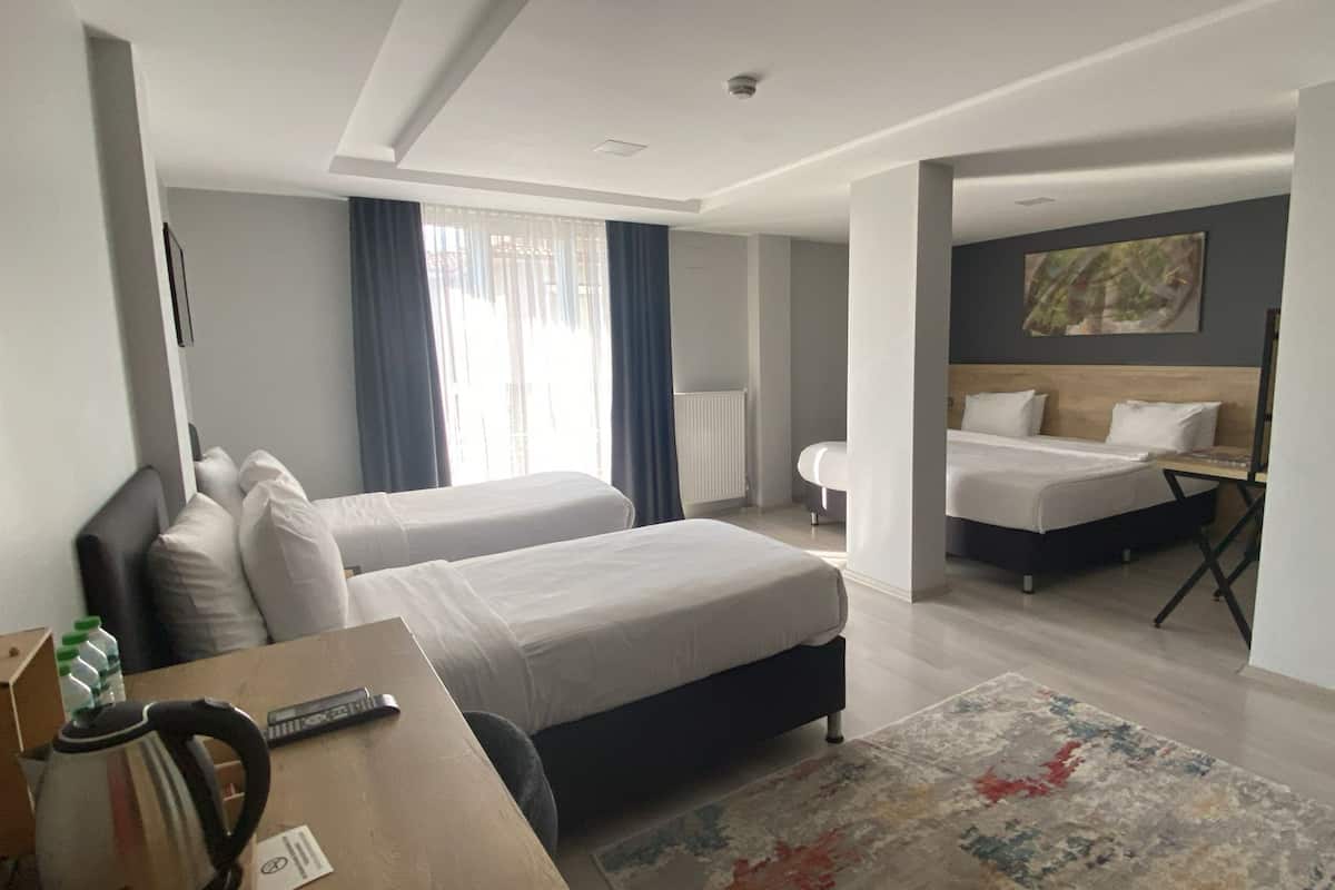 Chambre quadruple supérieure | Literie de qualité, minibar, coffre-fort, décor unique