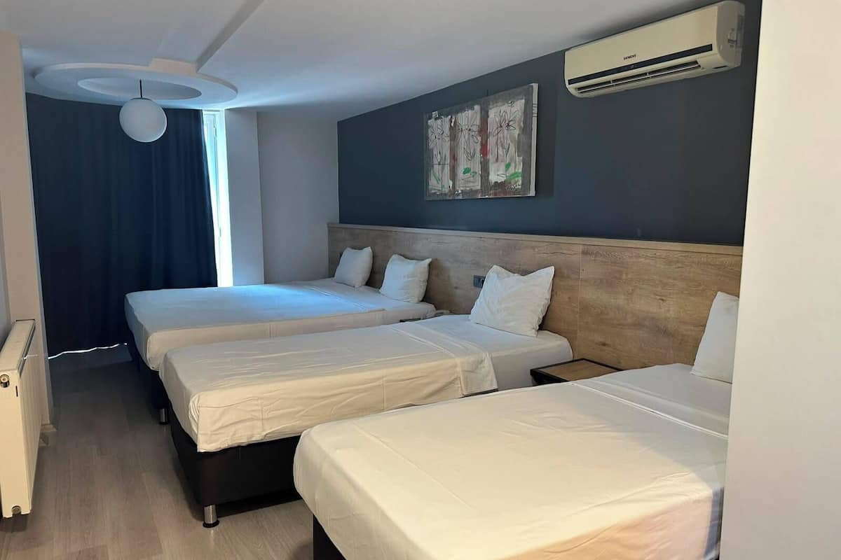 Superior Quadruple Room | Peralatan tempat tidur premium, bar mini, peti besi dalam bilik, meja 