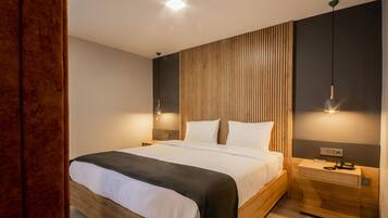 Un dormitorio moderno con un cabecero de madera, una mesita de noche con lámpara y una lámpara de pared.