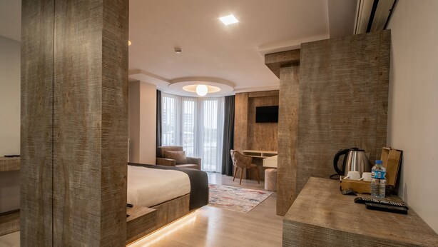Et moderne hotelværelse med en stor seng, et skrivebord og et siddeområde.