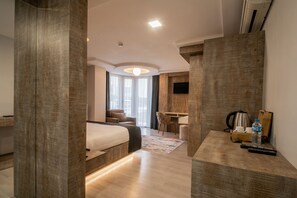 Una habitación de hotel moderna con una cama grande, un escritorio y una zona de estar.