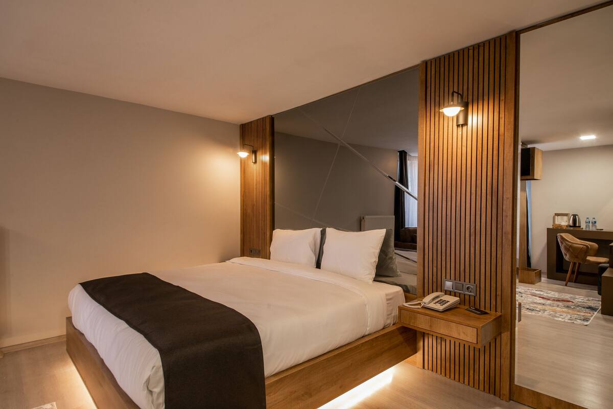 Deluxe Suite, City View, Corner | Peralatan tempat tidur premium, bar mini, peti besi dalam bilik, meja 