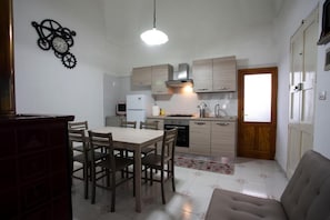 Une cuisine de taille réduite comprenant une table et des chaises, un réfrigérateur et un évier.