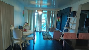 Un amplio espacio de sala con una mesa de comedor, sillas, un sofá y un mueble para televisión.
