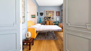 A bedroom with a bed, a chair, a desk, and a wardrobe. - Rooftop Views of the Arc de Triomphe, by Veeve (Paris)