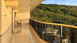 Un balcon donnant sur une colline verdoyante.