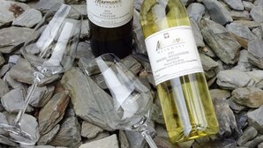 Two wine bottles and three wine glasses on a bed of stones. - Well-kept vacation home in the middle of the vineyards, apartment 2, short vacation on request (Osann)
