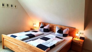 A double bed with a wooden headboard and two bedside tables, each with a lamp. - Well-kept vacation home in the middle of the vineyards, apartment 2, short vacation on request (Osann)