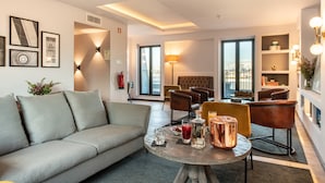 A modern living room with a sofa, armchairs, a coffee table, and a fireplace. - Pestana Lisboa Vintage City Center Suites (Lisbon)