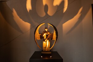 A golden statue of an angel with wings on a pedestal.