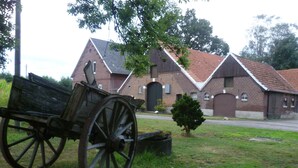 A rustic building with a brick facade and a traditional pitched roof. - Apartment right on the Dutch border (Oeding)