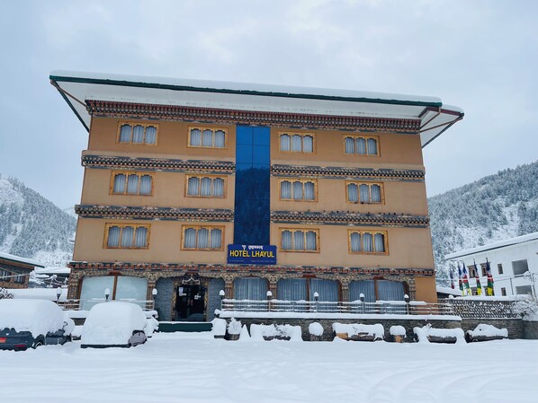 A multi-story hotel with a traditional architectural style, featuring a prominent entrance and a signboard. - Hotel Lhayul (Ha)