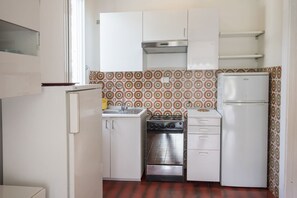 A compact kitchen with white cabinets, a stove, oven, and a refrigerator. - M104 - Marcelli, villa with garden 200 meters from the sea (Marcelli)