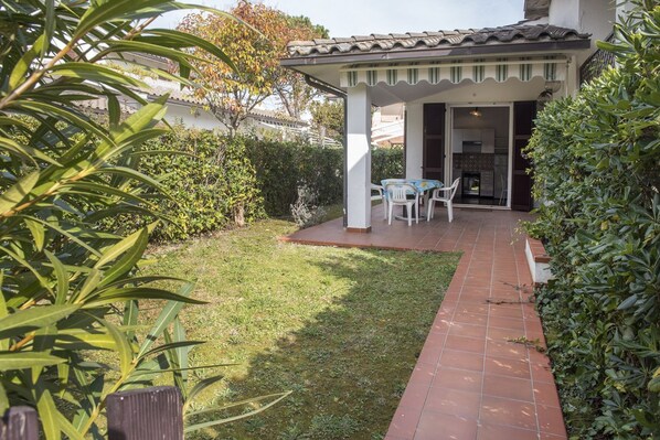 A patio with a table and chairs, a covered area, and a well-maintained lawn. - M104 - Marcelli, villa with garden 200 meters from the sea (Marcelli)