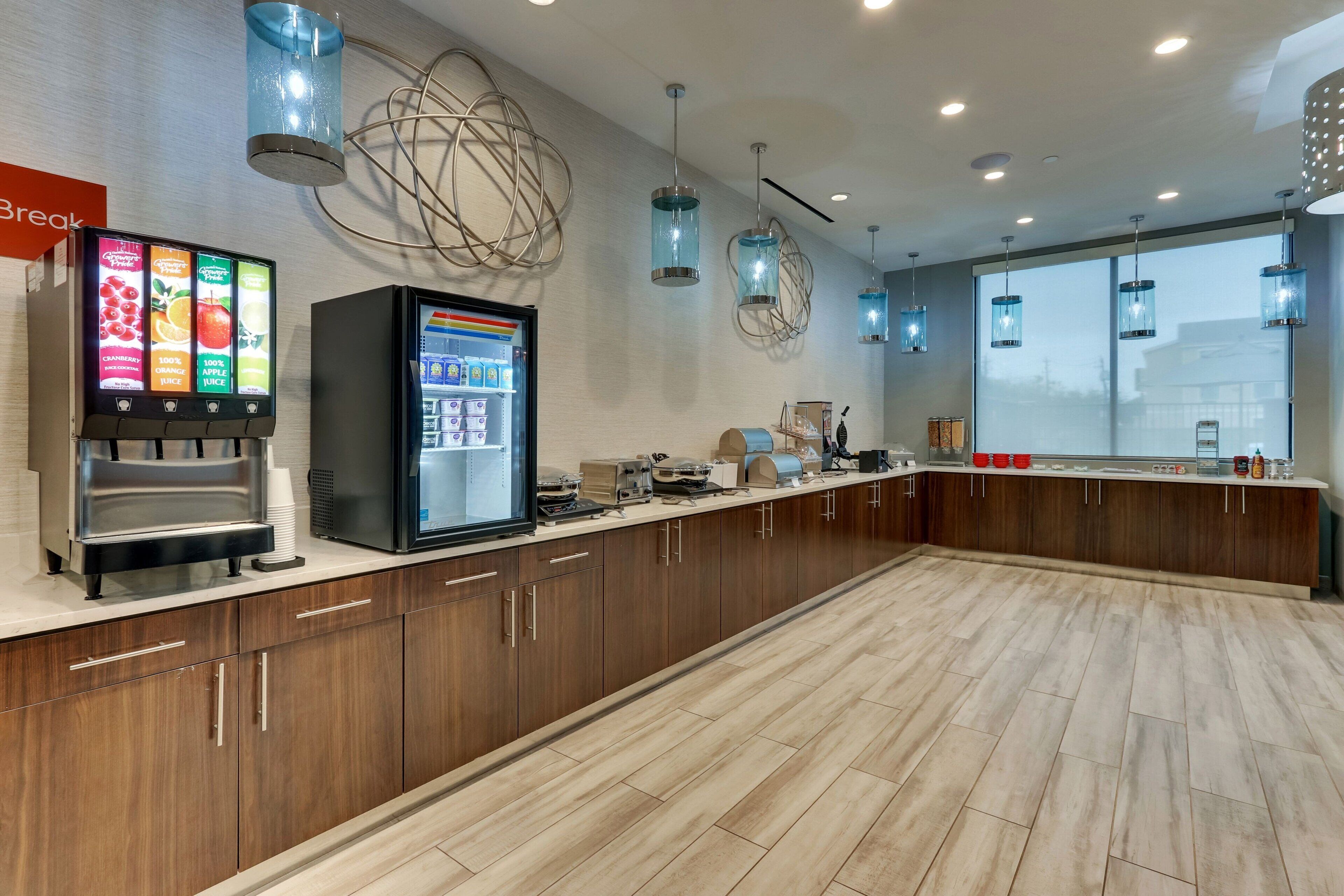 Una cocina moderna con una estación de café, un refrigerador y un ventanal grande.