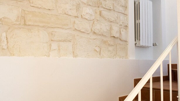 A staircase with a white railing leading to a room with a stone wall. - N216 - Numana, sky-earth in the alleys 200mt from the sea (Numana)