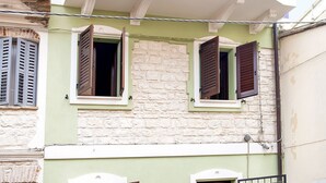 A building with two open windows, a stone facade, and a white balcony. - N216 - Numana, sky-earth in the alleys 200mt from the sea (Numana)