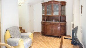 A room with a wooden cabinet, a chair, a desk with a computer, and a staircase. - N216 - Numana, sky-earth in the alleys 200mt from the sea (Numana)