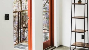Ein Flur mit einer Holztür und einem Metallregal.