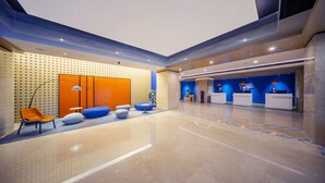 A modern lobby with a reception desk, seating area, and a patterned wall. - Holiday Inn Express Hangzhou Westlake East by IHG (Hangzhou)