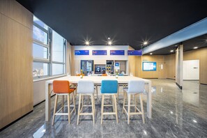 Una sala de conferencias moderna con una larga mesa, cuatro sillas y un amplio ventanal.