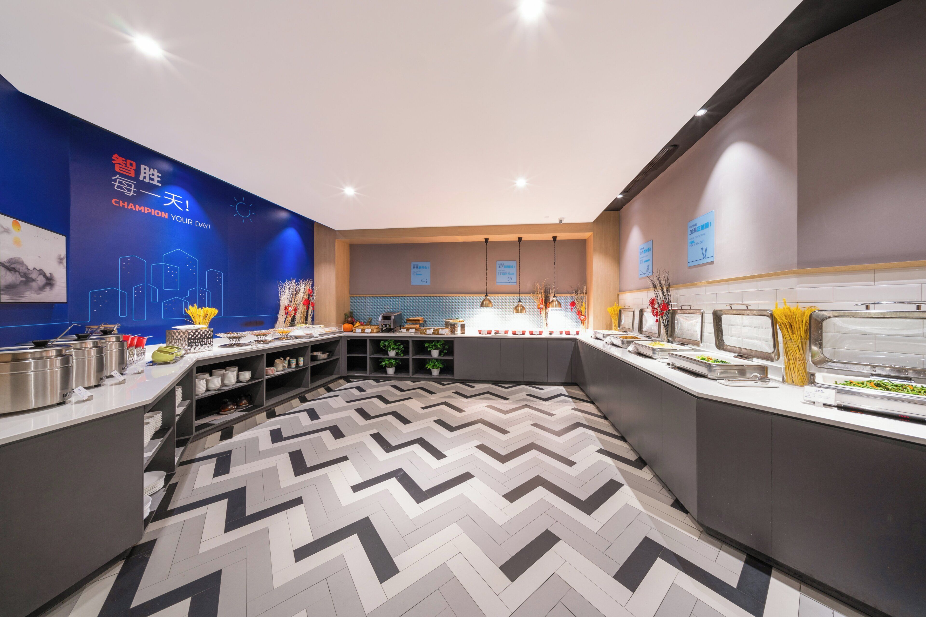 A modern buffet area with a variety of food options, a patterned floor, and a blue wall with a cityscape graphic.