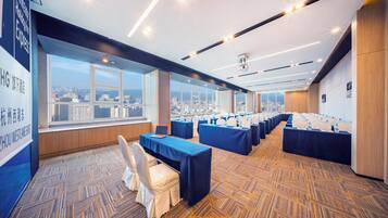A conference room with multiple tables, chairs, and a city view.