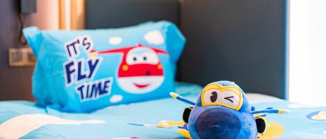 Un letto con un cuscino blu raffigurante un personaggio dei cartoni animati e il testo 'It's Fly Time'.