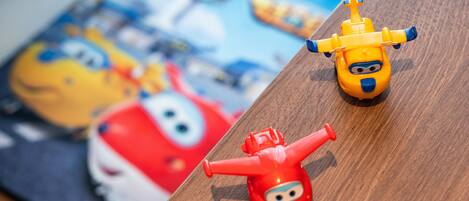 Two toy helicopters on a wooden surface with a blurred background.