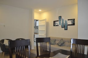 A modern living room with a sofa, two armchairs, a dining table, and a kitchen in the background. - Montevideo, Centro Edificio El Pais (Montevideo)