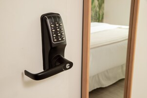 Uma porta com fechadura eletrônica de teclado numérico e olho de fechadura.